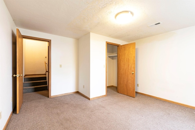 470 Strand Ave, Missoula, MT 59801 - unfurnished bedroom with light colored carpet, a closet, and a textured ceiling
