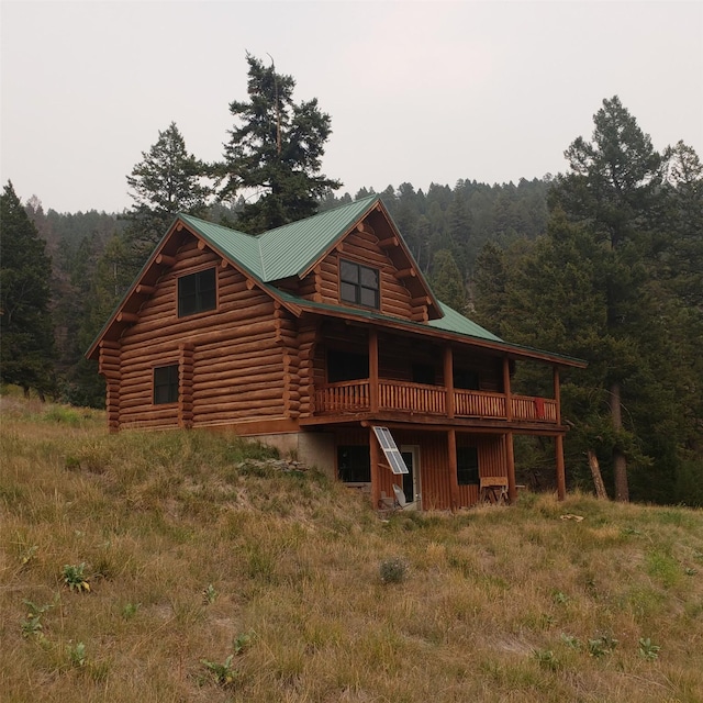 6958 Brock Creek Rd, Garrison, MT 59731 - back of house featuring a view of trees, log exterior, a metal roof, and a deck