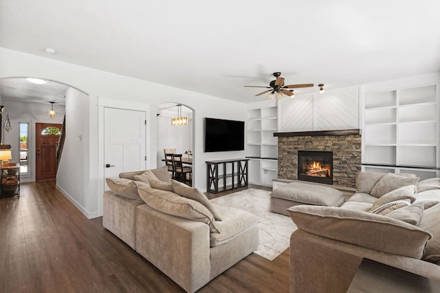 36 Silo St, Belgrade, MT 59714 - living area with arched walkways, dark wood-type flooring, a ceiling fan, built in features, and a stone fireplace
