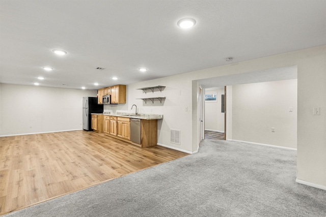 1940 Dixon Ave, Missoula, MT 59801 - kitchen with appliances with stainless steel finishes, recessed lighting, open floor plan, light carpet, and brown cabinets