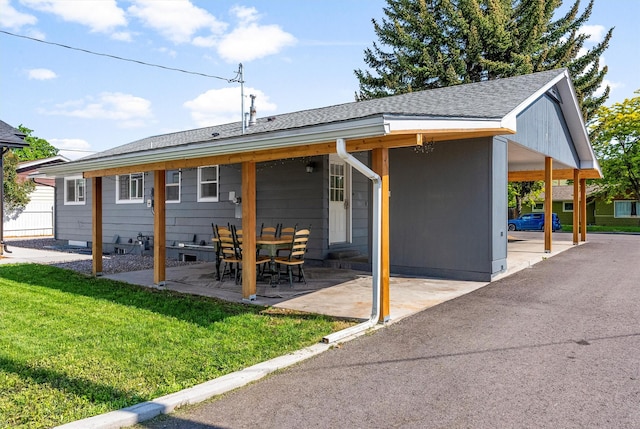 1940 Dixon Ave, Missoula, MT 59801 - rear view of house featuring a lawn, a shingled roof, and a patio