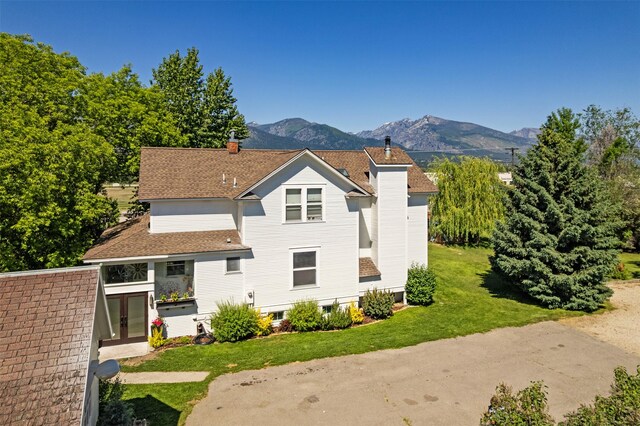 101 Lewis Ln, Hamilton, MT 59840 - back of property with a chimney, a mountain view, a yard, and french doors