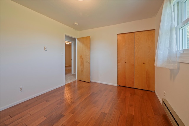 5706 Shannon Ct, Helena, MT 59602 - unfurnished bedroom with a baseboard heating unit, wood finished floors, and a closet