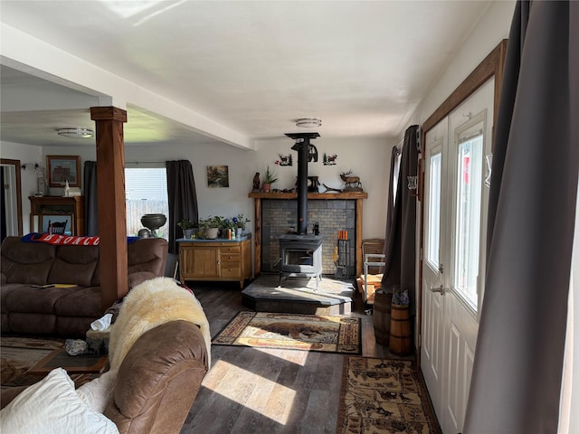 306 E Missoula Ave, Troy, MT 59935 - living area with dark wood finished floors, decorative columns, and a wood stove