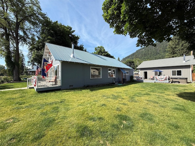 306 E Missoula Ave, Troy, MT 59935 - rear view of property featuring a deck, a yard, and a metal roof