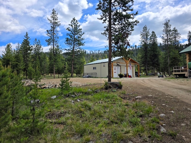 223 E G St, Sula, MT 59871 - view of home's exterior featuring a detached garage, an outdoor structure, and dirt driveway
