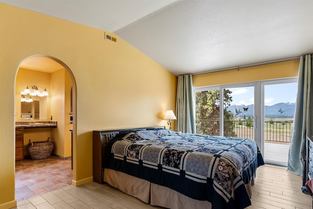 2813 Pine Lakes Ct, Stevensville, MT 59870 - bedroom featuring access to outside, arched walkways, lofted ceiling, and connected bathroom