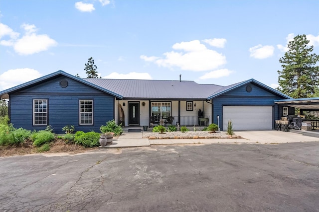2813 Pine Lakes Ct, Stevensville, MT 59870 - ranch-style house featuring covered porch, an attached garage, driveway, and a metal roof