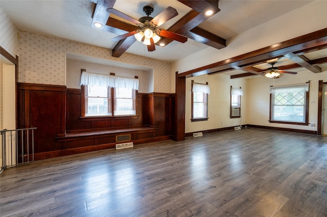 1805 2nd Ave N, Great Falls, MT 59401 - unfurnished living room with ceiling fan, beamed ceiling, a wainscoted wall, dark wood finished floors, and wallpapered walls