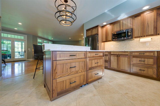 8785 Jacot Ln, Missoula, MT 59808 - kitchen featuring appliances with stainless steel finishes, tasteful backsplash, a kitchen island, recessed lighting, and light tile patterned floors