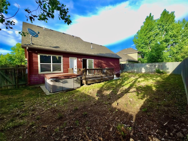 1109 Wyoming St, Belgrade, MT 59714 - back of property featuring a hot tub, a fenced backyard, a wooden deck, and roof with shingles