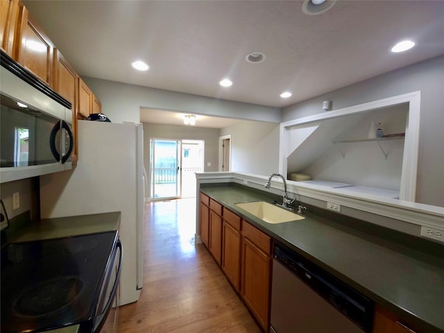 1109 Wyoming St, Belgrade, MT 59714 - kitchen featuring appliances with stainless steel finishes, brown cabinets, light wood-type flooring, dark countertops, and recessed lighting