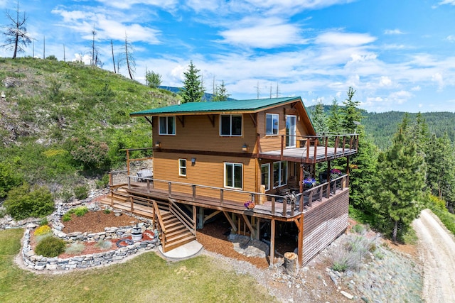 298 Lone Wolf Trl, Lakeside, MT 59922 - rear view of property featuring a deck, stairway, and a forest view
