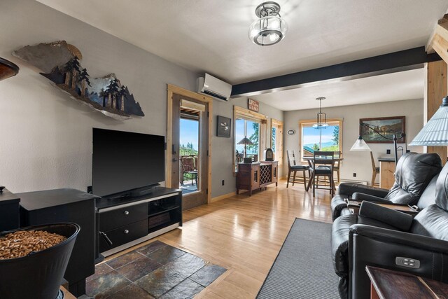 298 Lone Wolf Trl, Lakeside, MT 59922 - living area with a wall unit AC, light wood-type flooring, and beamed ceiling