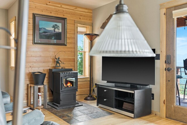 298 Lone Wolf Trl, Lakeside, MT 59922 - living area with wood walls, a wood stove, plenty of natural light, and wood finished floors