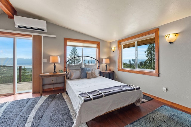 298 Lone Wolf Trl, Lakeside, MT 59922 - bedroom featuring a wall mounted AC, wood finished floors, access to outside, and a mountain view