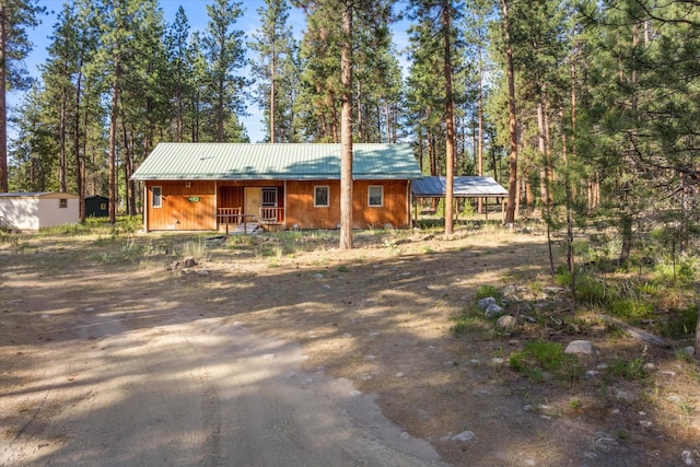 452 Blair Ln, Victor, MT 59875 - view of front of home featuring a metal roof, driveway, a shed, and a porch
