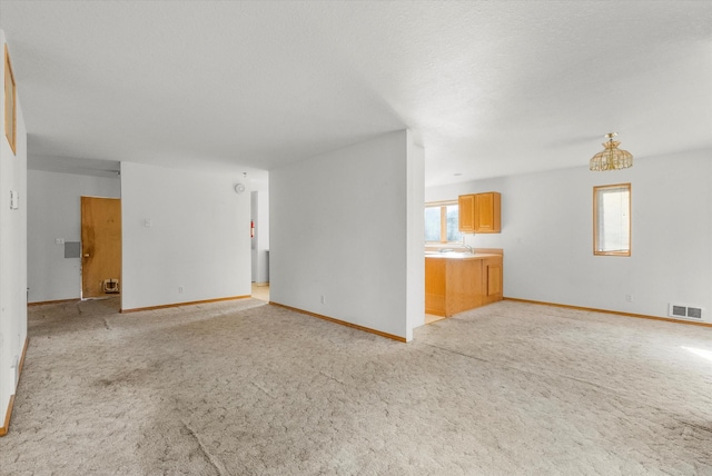 452 Blair Ln, Victor, MT 59875 - unfurnished living room featuring light colored carpet and a chandelier