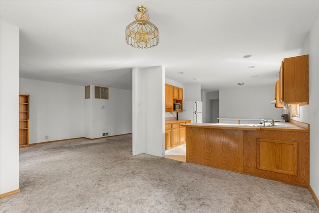 452 Blair Ln, Victor, MT 59875 - kitchen featuring light colored carpet, open floor plan, freestanding refrigerator, stainless steel microwave, and a peninsula