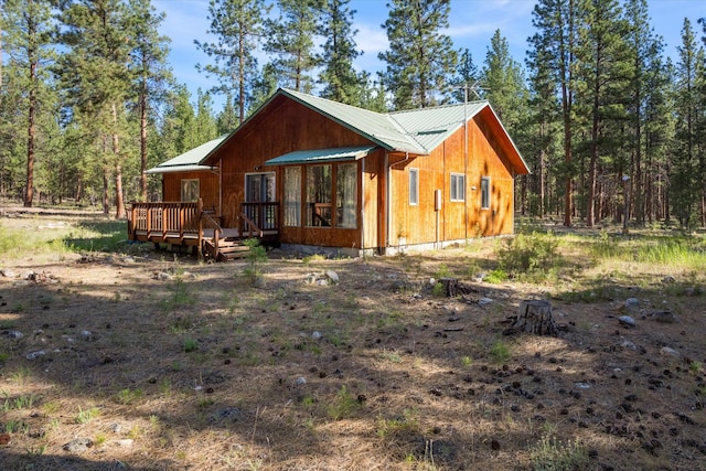 452 Blair Ln, Victor, MT 59875 - view of front facade with a wooden deck, a metal roof, and a view of trees