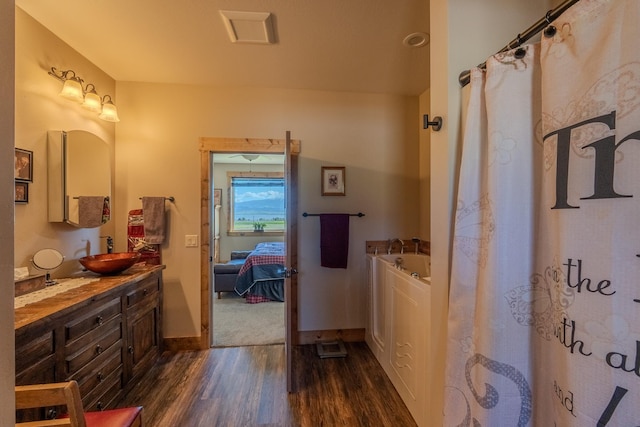 51 Whitehorse Rd, Townsend, MT 59644 - ensuite bathroom with wood finished floors, double vanity, a bath, and a shower with shower curtain