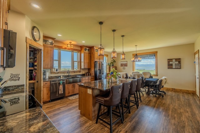 51 Whitehorse Rd, Townsend, MT 59644 - kitchen with stainless steel appliances, brown cabinetry, dark wood-style floors, a breakfast bar, and a kitchen island