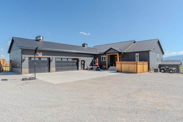 51 Whitehorse Rd, Townsend, MT 59644 - view of front facade with concrete driveway, an attached garage, a chimney, a metal roof, and a standing seam roof