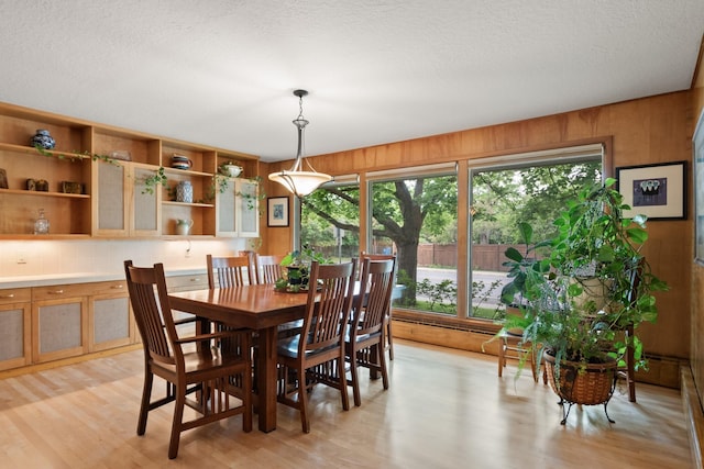 1700 Arthur Ave, Missoula, MT 59801 - dining area with light wood-type flooring, healthy amount of natural light, wood walls, and a textured ceiling