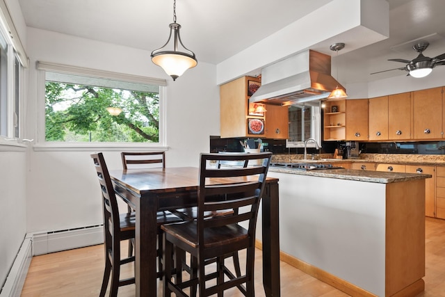 1700 Arthur Ave, Missoula, MT 59801 - kitchen with island exhaust hood, light wood-style flooring, ceiling fan, baseboard heating, and decorative light fixtures