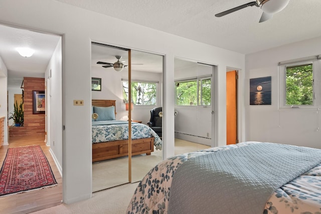 1700 Arthur Ave, Missoula, MT 59801 - bedroom with light wood-style flooring, two closets, a textured ceiling, and a ceiling fan
