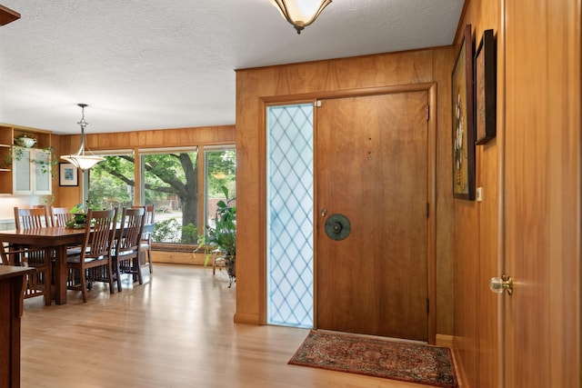 1700 Arthur Ave, Missoula, MT 59801 - entrance foyer with light wood-style flooring, a textured ceiling, and wood walls