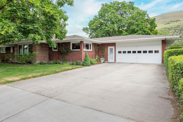 1700 Arthur Ave, Missoula, MT 59801 - single story home featuring an attached garage, concrete driveway, a front yard, brick siding, and a mountain view