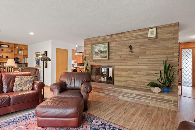 1700 Arthur Ave, Missoula, MT 59801 - living area with wood finished floors, a textured ceiling, a brick fireplace, brick wall, and recessed lighting