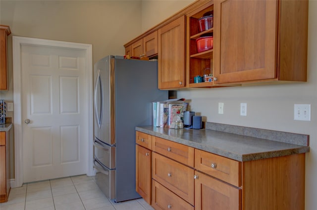 3250 Stillwell Dr, Helena, MT 59602 - kitchen featuring freestanding refrigerator, brown cabinets, dark countertops, and light tile patterned flooring