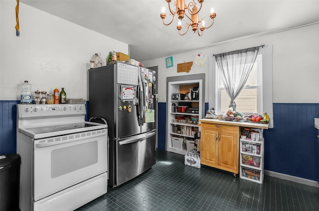 1126 4th Ave S, Great Falls, MT 59405 - kitchen with white electric stove, freestanding refrigerator, a chandelier, a wainscoted wall, and dark tile patterned flooring