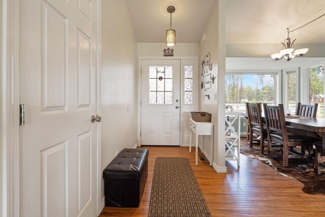 791 Springwood Ln, Kalispell, MT 59901 - foyer with a chandelier, wood finished floors, and vaulted ceiling