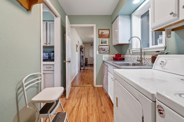791 Springwood Ln, Kalispell, MT 59901 - laundry room featuring cabinet space, washer and clothes dryer, light wood finished floors, and a textured wall
