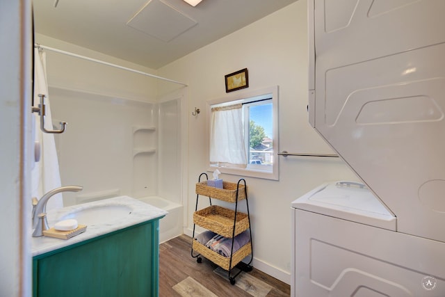 820 11th Ave, Helena, MT 59601 - bathroom featuring wood finished floors, vanity, stacked washer and clothes dryer, and shower / tub combo with curtain