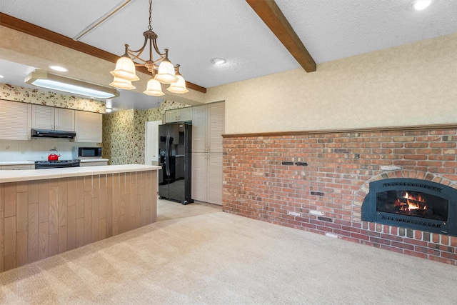 1229 Old Orchard Rd, Missoula, MT 59802 - kitchen with appliances with stainless steel finishes, under cabinet range hood, light countertops, a chandelier, and beamed ceiling