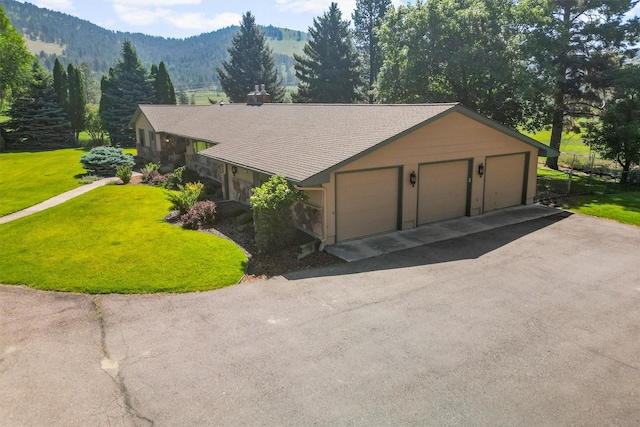 1229 Old Orchard Rd, Missoula, MT 59802 - view of front of home featuring a front yard, a mountain view, a garage, stone siding, and a chimney