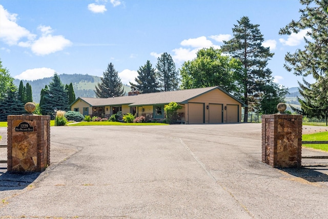 1229 Old Orchard Rd, Missoula, MT 59802 - single story home with an attached garage, a chimney, and a mountain view