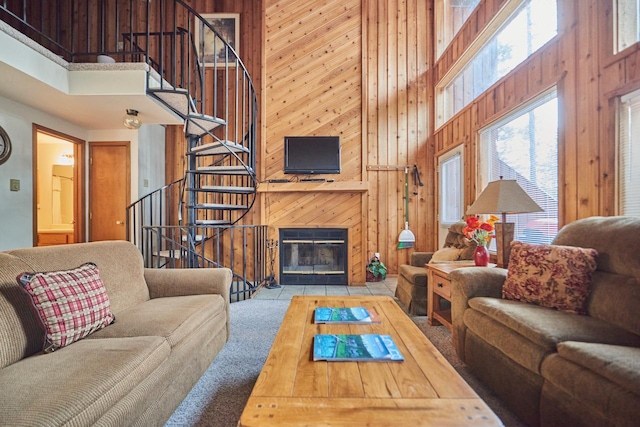 118 Ptarmigan Blvd Unit 118, Whitefish, MT 59937 - living room featuring a towering ceiling, a fireplace with flush hearth, wooden walls, stairway, and carpet floors