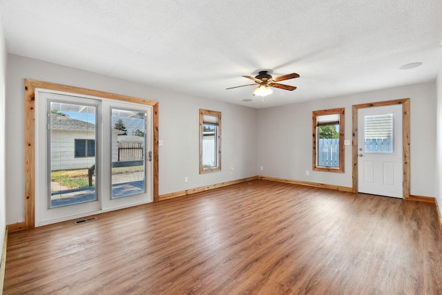 3121 6th Ave S, Great Falls, MT 59405 - unfurnished room featuring wood finished floors, plenty of natural light, ceiling fan, and a textured ceiling