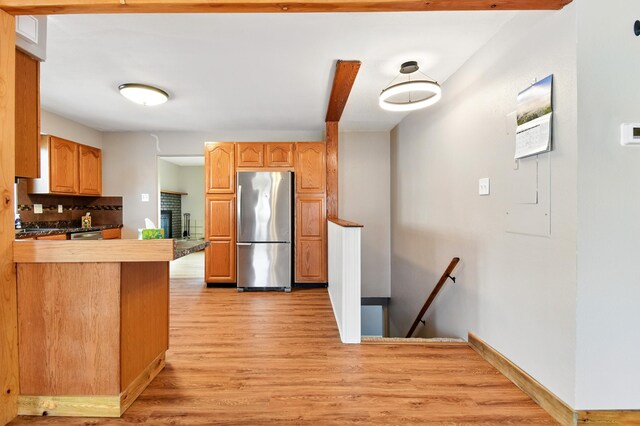 3121 6th Ave S, Great Falls, MT 59405 - kitchen featuring freestanding refrigerator, light wood-style flooring, a peninsula, and tasteful backsplash