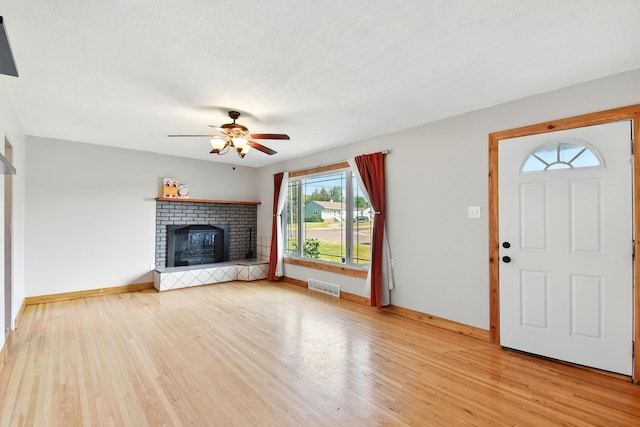 3121 6th Ave S, Great Falls, MT 59405 - unfurnished living room featuring light wood-style flooring, a ceiling fan, and a brick fireplace