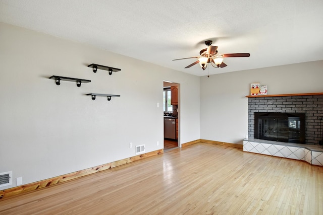 3121 6th Ave S, Great Falls, MT 59405 - unfurnished living room featuring wood finished floors, a ceiling fan, and a brick fireplace