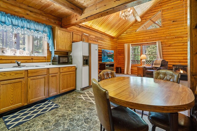 72 Giefer Creek Rd, Essex, MT 59916 - dining room with a wood ceiling with exposed beams, rustic walls, a chandelier, dark stone finish flooring, and high vaulted ceiling