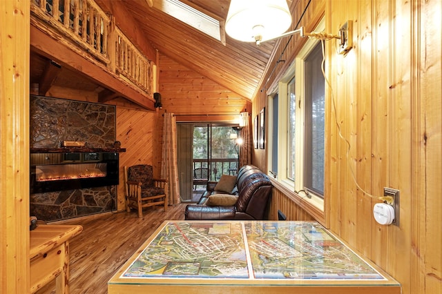 24 Alder Way Unit 3B, Whitefish, MT 59937 - sitting room with wood walls, lofted ceiling, wood finished floors, a stone fireplace, and wooden ceiling