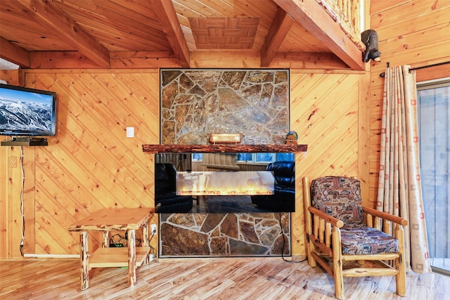 24 Alder Way Unit 3B, Whitefish, MT 59937 - sitting room featuring a wood ceiling with exposed beams, wood walls, wood finished floors, and a stone fireplace