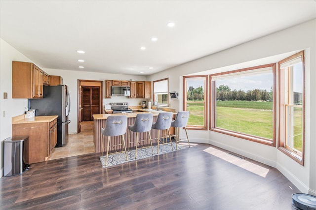 3446 Tizer Dr, Helena, MT 59602 - kitchen featuring appliances with stainless steel finishes, brown cabinetry, light countertops, recessed lighting, and light wood-type flooring